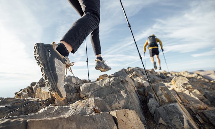 Two hikers on rocky terrain wearing the Oboz Katabatic Low hiking shoes.