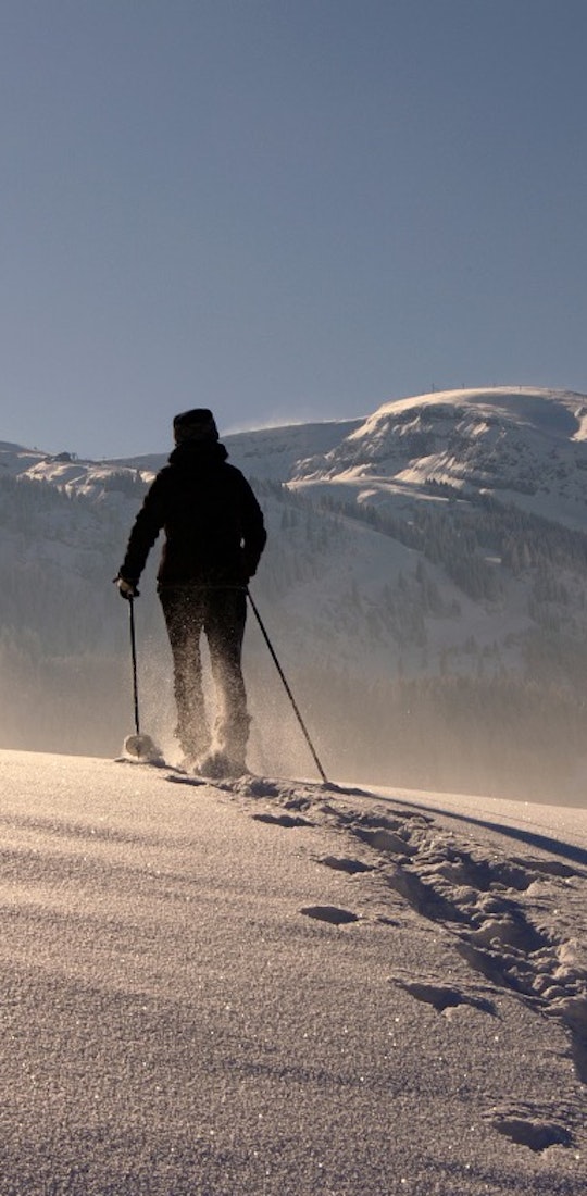 Skier in the backcountry ascending a snowy mountain with a touring set up.