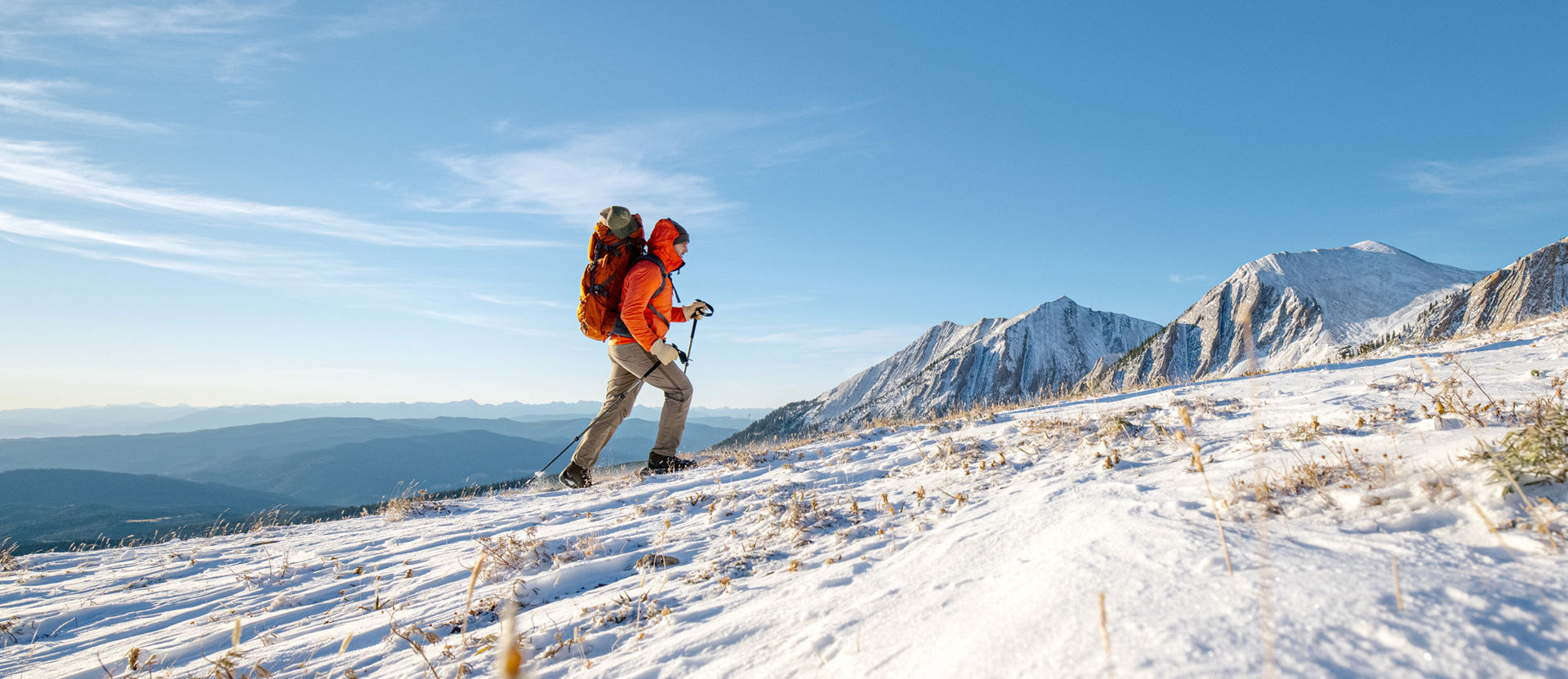Man hiking snowy mountain peaks in Oboz winter boots