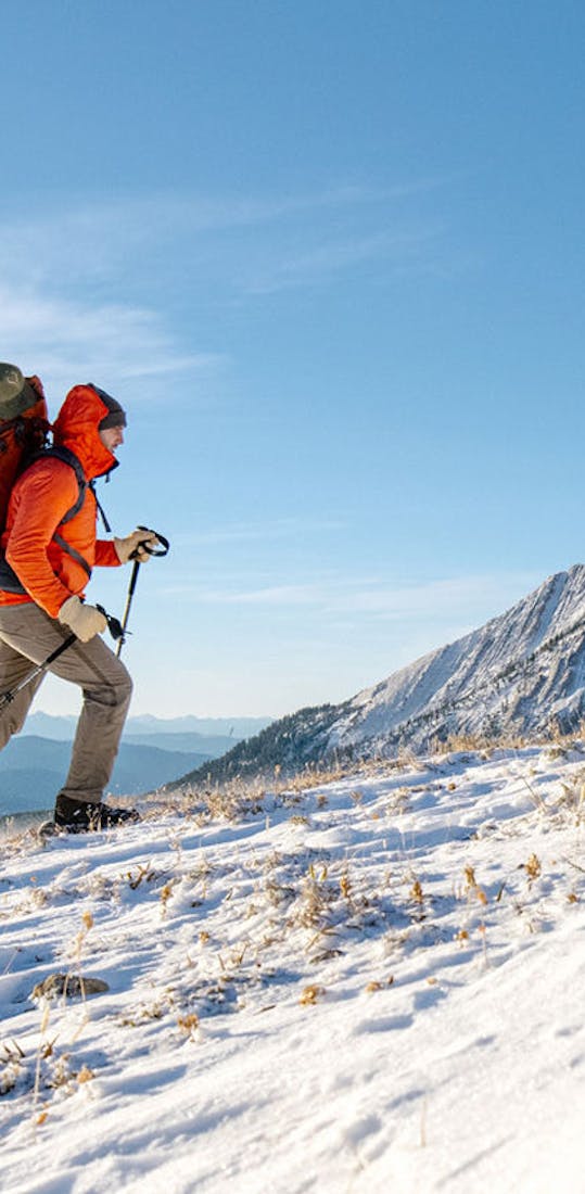 Man hiking snowy mountain peaks in Oboz winter boots