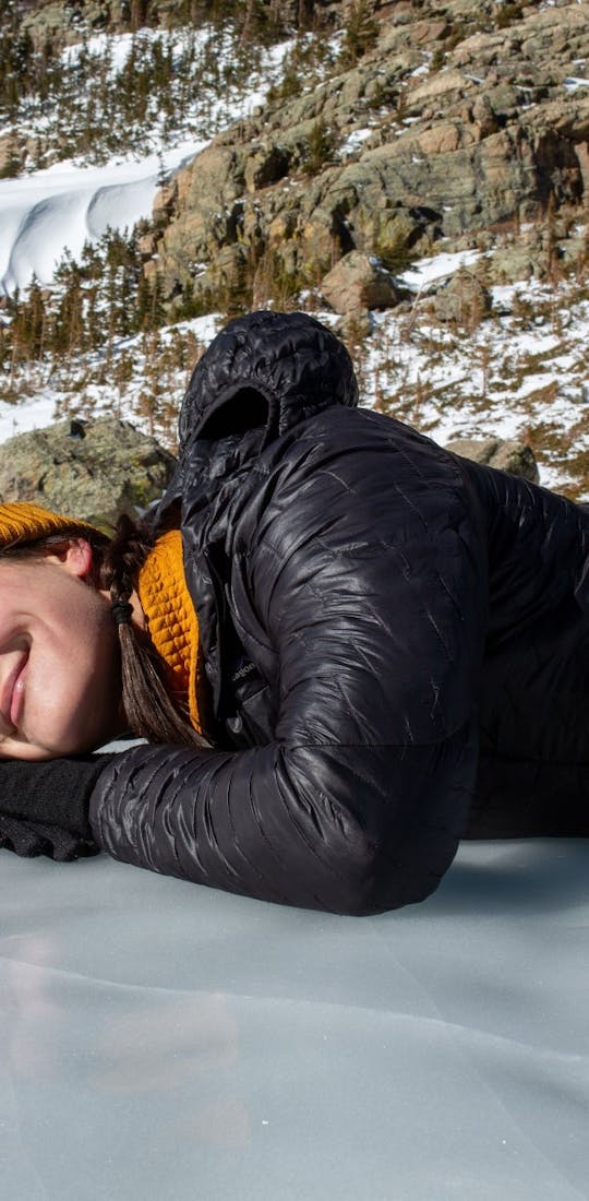 Kylie Yang lays on a frozen lake during winter hike.