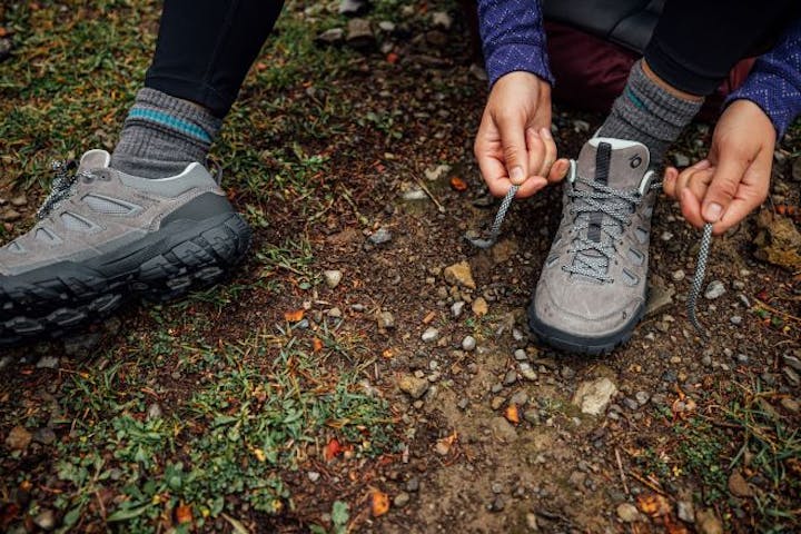 Oboz Sawtooth X Low being tied by a hiker.
