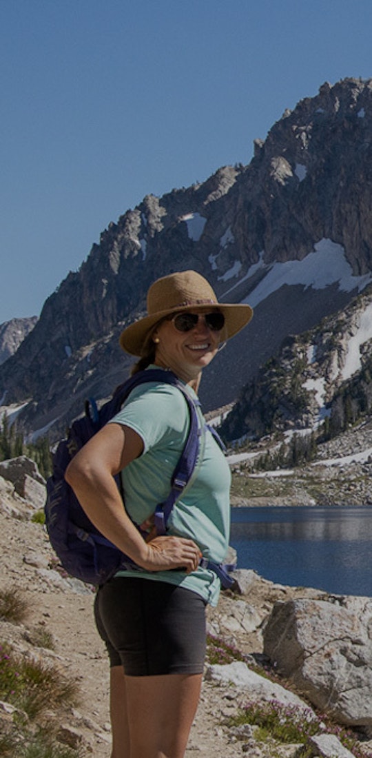 Kristen Bor of Bearfoot Theory smiling for a picture at a snowy mountain lake.