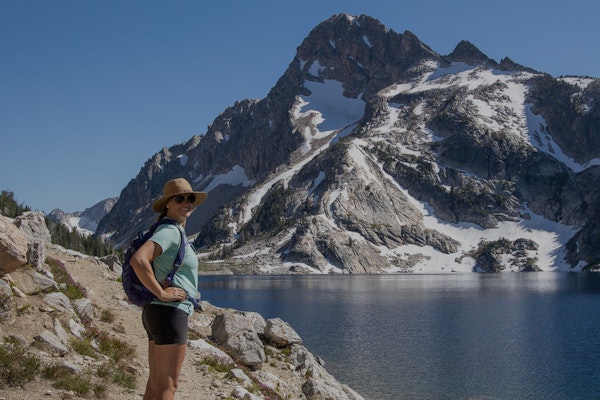 Kristen Bor of Bearfoot Theory smiling for a picture at a snowy mountain lake.