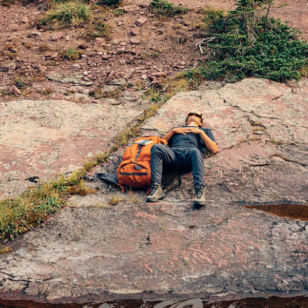 Hiker taking a rest on the trail in the Oboz Sawtooth X Mid hiking boots.