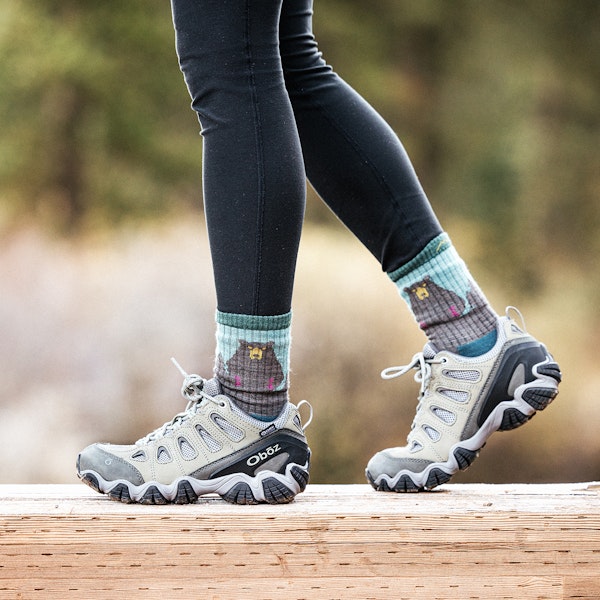 Woman wearing Oboz Sawtooth II Low B-DRY on a wood bridge.