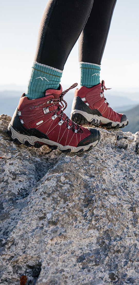 Oboz Bridger Mid Rio Red Hiking Boots on a rocky mountain peak.