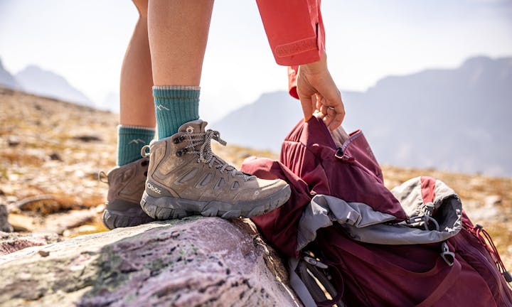 Hiker in an Oboz Sawtooth X mid height hiking shoe adjusting their backpack.