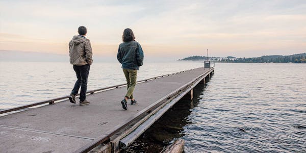 Two people walking on a boardwalk in Oboz Bozeman Low casual shoes.