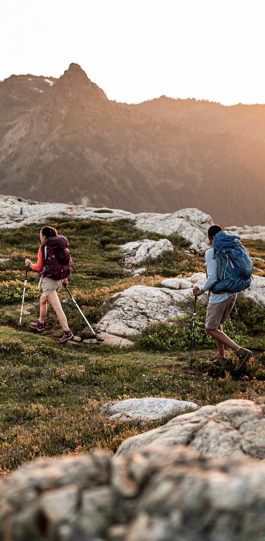 Hikers on the beautiful trail in the evening with mountains in the background