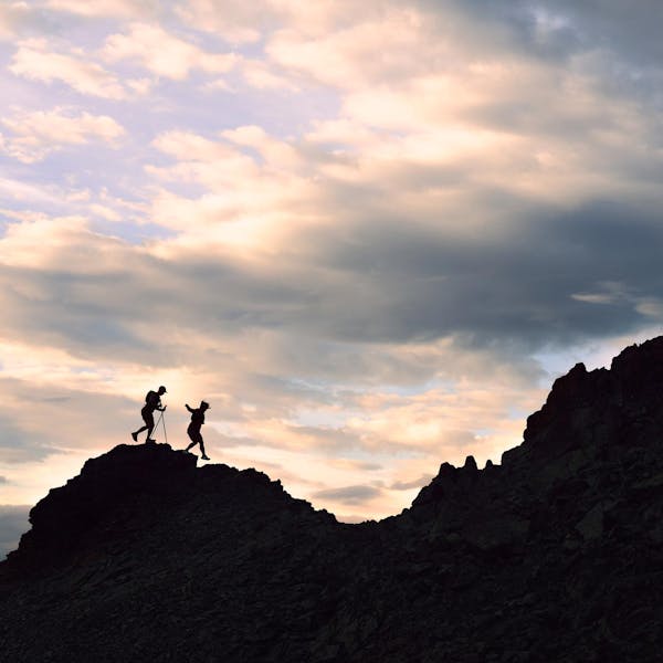 Two hikers trail running up a rocky face in Oboz Katabatic Wind shoes.