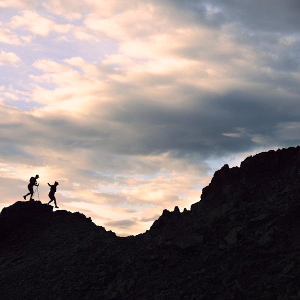 Two hikers trail running up a rocky face in Oboz Katabatic Wind shoes.