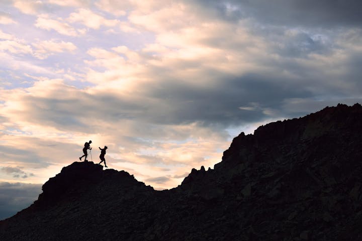 Two hikers trail running up a rocky face in Oboz Katabatic Wind shoes.