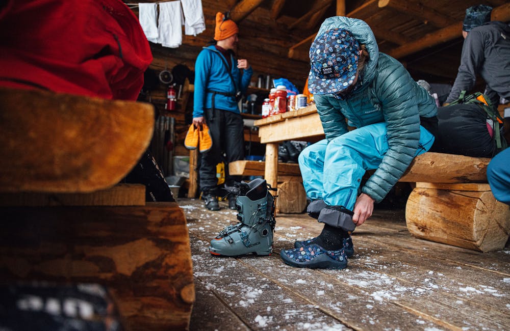 A woman puts on the Oboz and Skida Whakatā Puffy's after a day of skiing