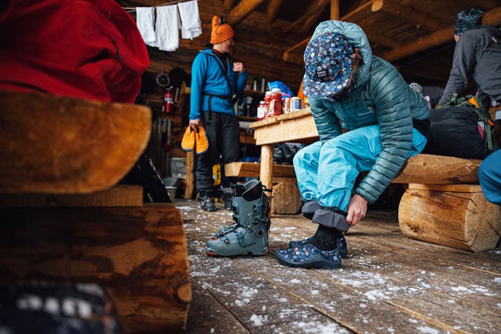 A woman puts on the Oboz and Skida Whakatā Puffy's after a day of skiing