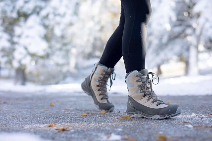 A woman in Oboz Ousel snow boots walks a snowy path in Bozeman.