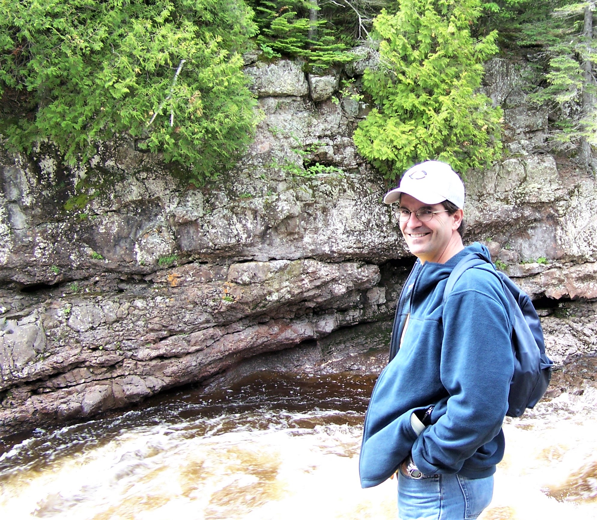 Oboz Footwear Trailblazer Joel Meline hiking next to a creek.
