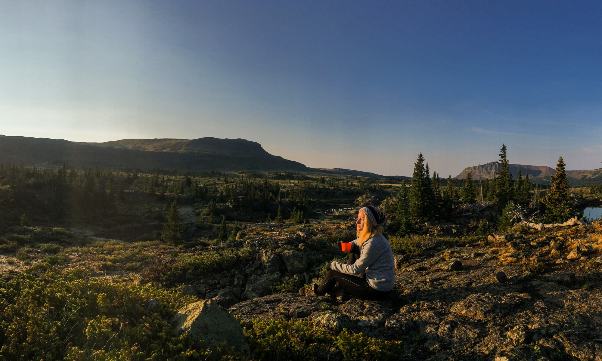 Camper viewing the beautiful sunset in the wilderness while after a hike.