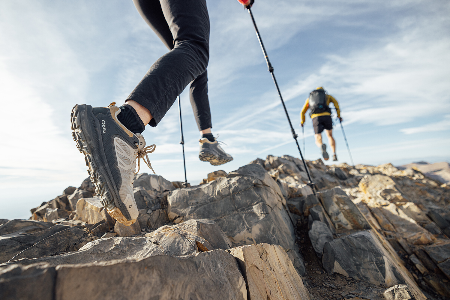 Two hikers on rocky terrain wearing the Oboz Katabatic Low hiking shoes.