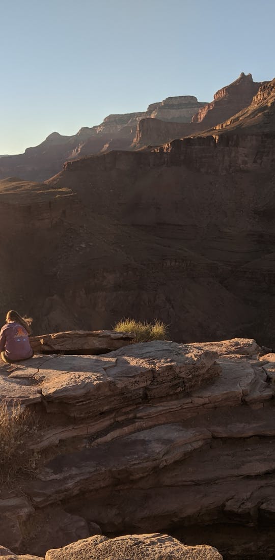 Hiker overlooking canyon on a bright, sunny day