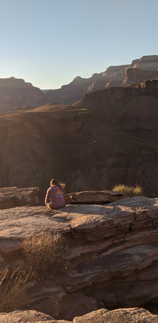 Two hikers overlooking a canyon on a bright, sunny day