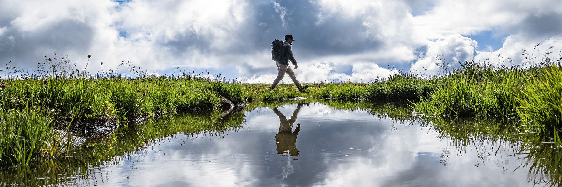 Oboz Footwear Trailblazer Evan Gill hiking across a marsh.