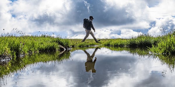 Oboz Footwear Trailblazer Evan Gill hiking across a marsh.