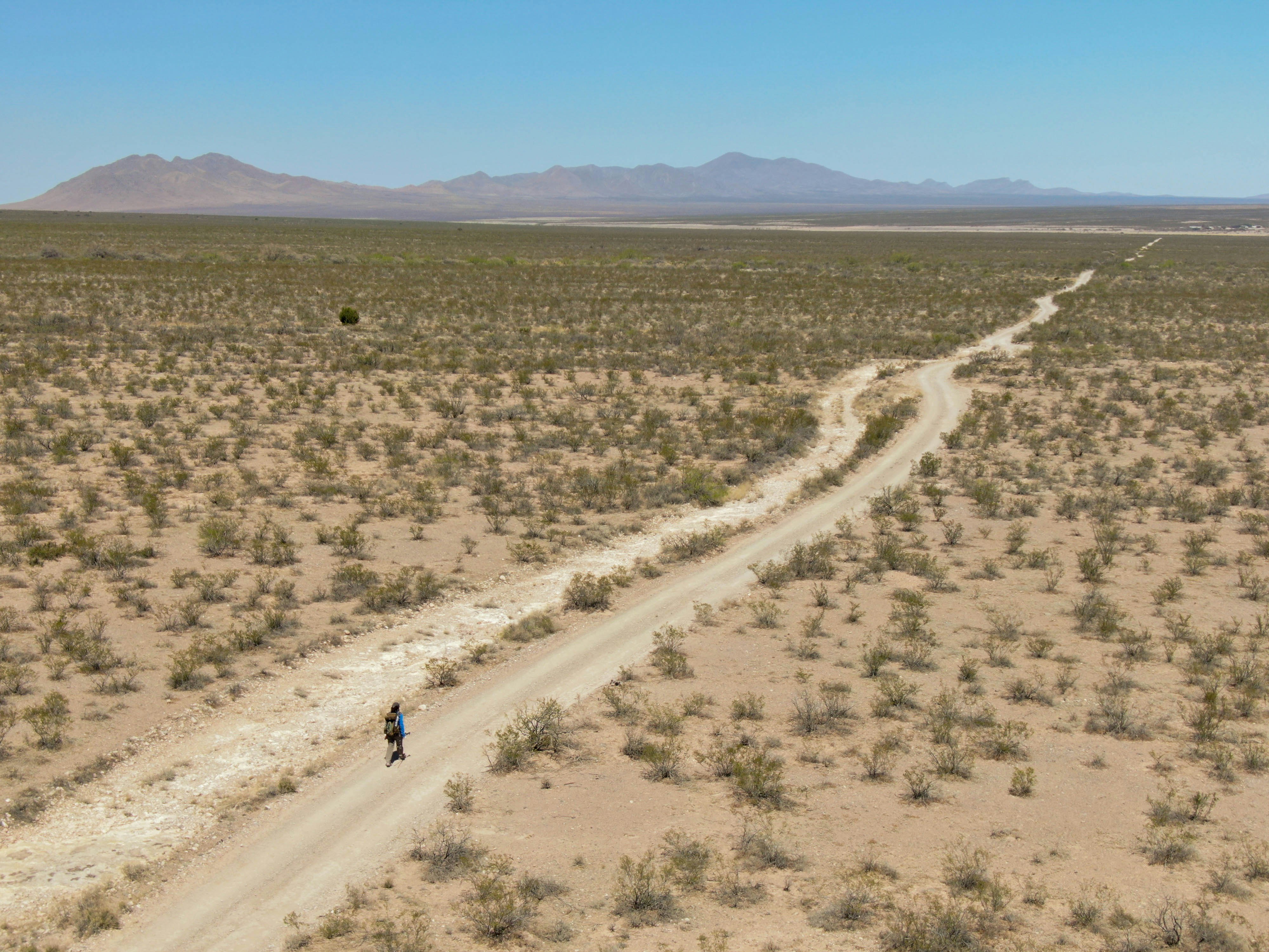 Drone shot of a hiker in a hot, open desert section of the Continental Divide Trail.