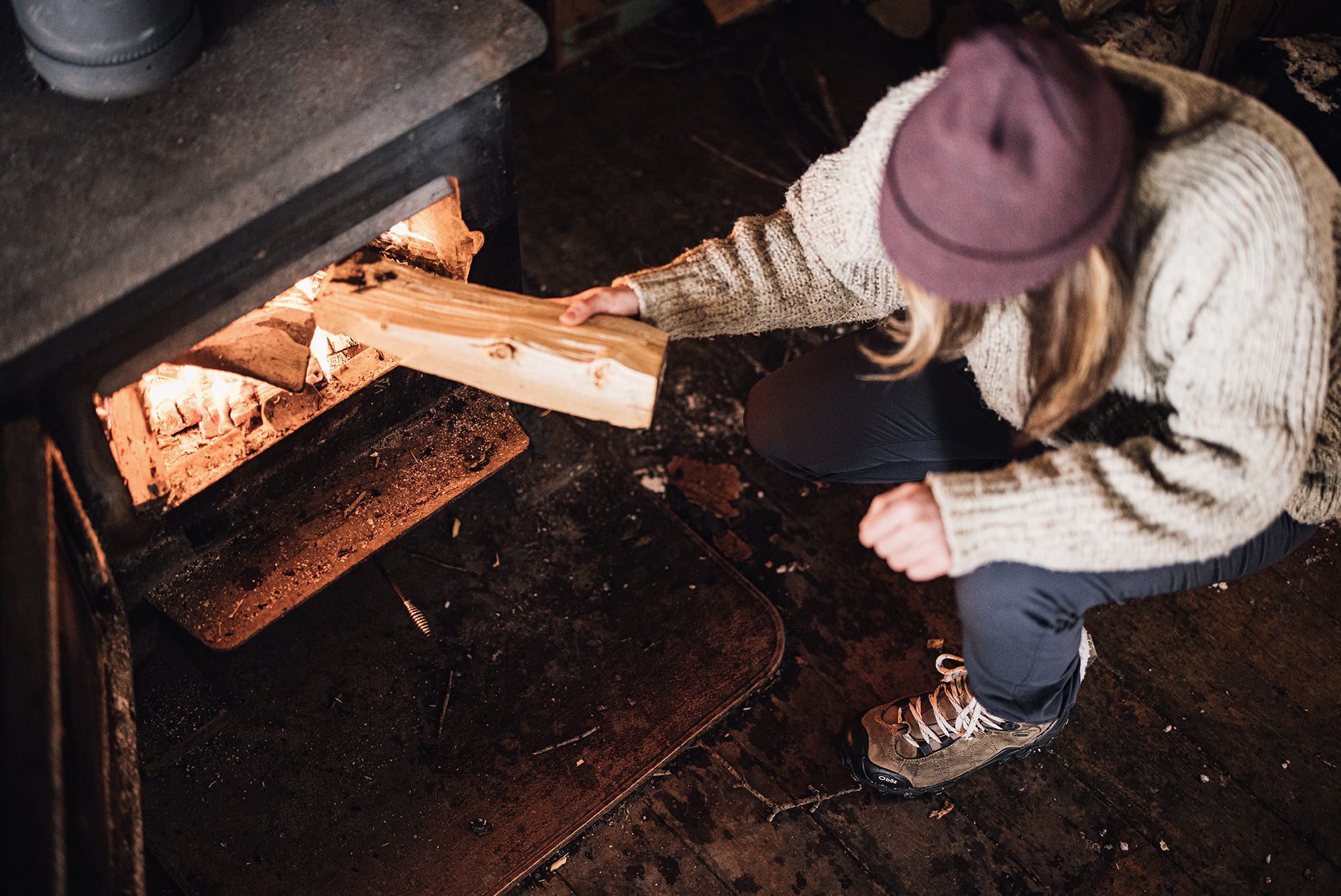Woman stoking the fire in the Oboz Bridger Winter Insulated Boots.